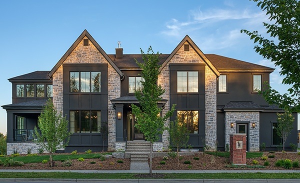 A Transitional Home with Bold Black Siding and Stone from the Ground to the Top of Gables