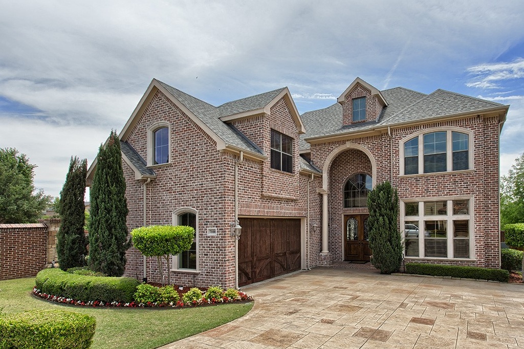 a traditional brick home with a front side-entry garage