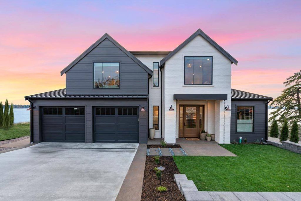 a modern farmhouse with two stories, volume, and tons of brightening windows