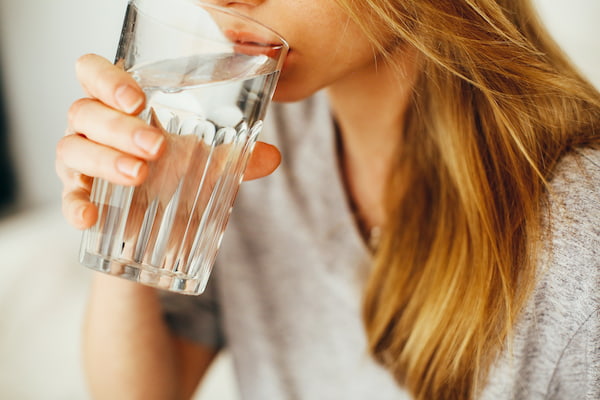 A Woman Taking a Drink of Water from a Glass -- Photo by Daria Shevtsova from Pexels