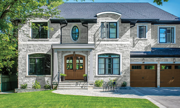 A Broad Home with Stone Siding and an Arched Double Door Entry for a Traditional Feel