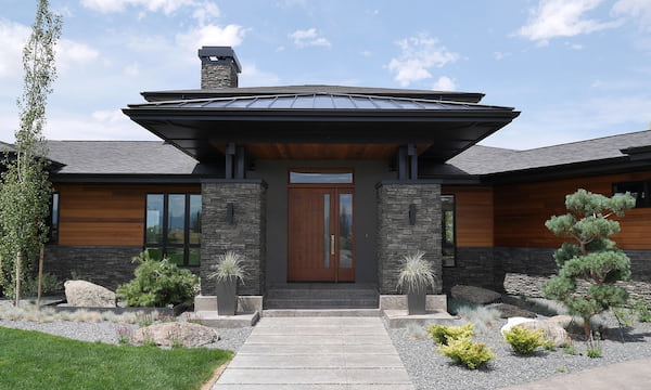 A Prairie-Style Home with Dark Stone Accents Alongside Wood Lap Siding