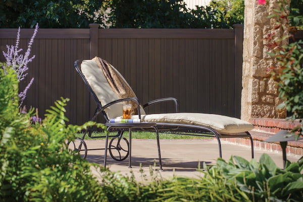 A Patio Lounge Chair in Front of a Solid Privacy Fence