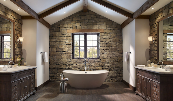 A Bathroom with Rugged Stone Behind the Tub and Vanities
